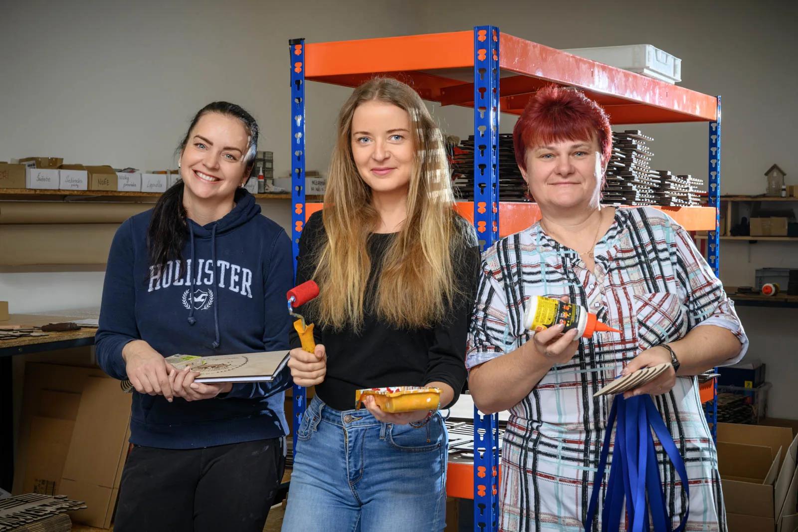 Tři kolegyně z dílny HOORAY se stuhami, lepidlem a válečkem v rukou