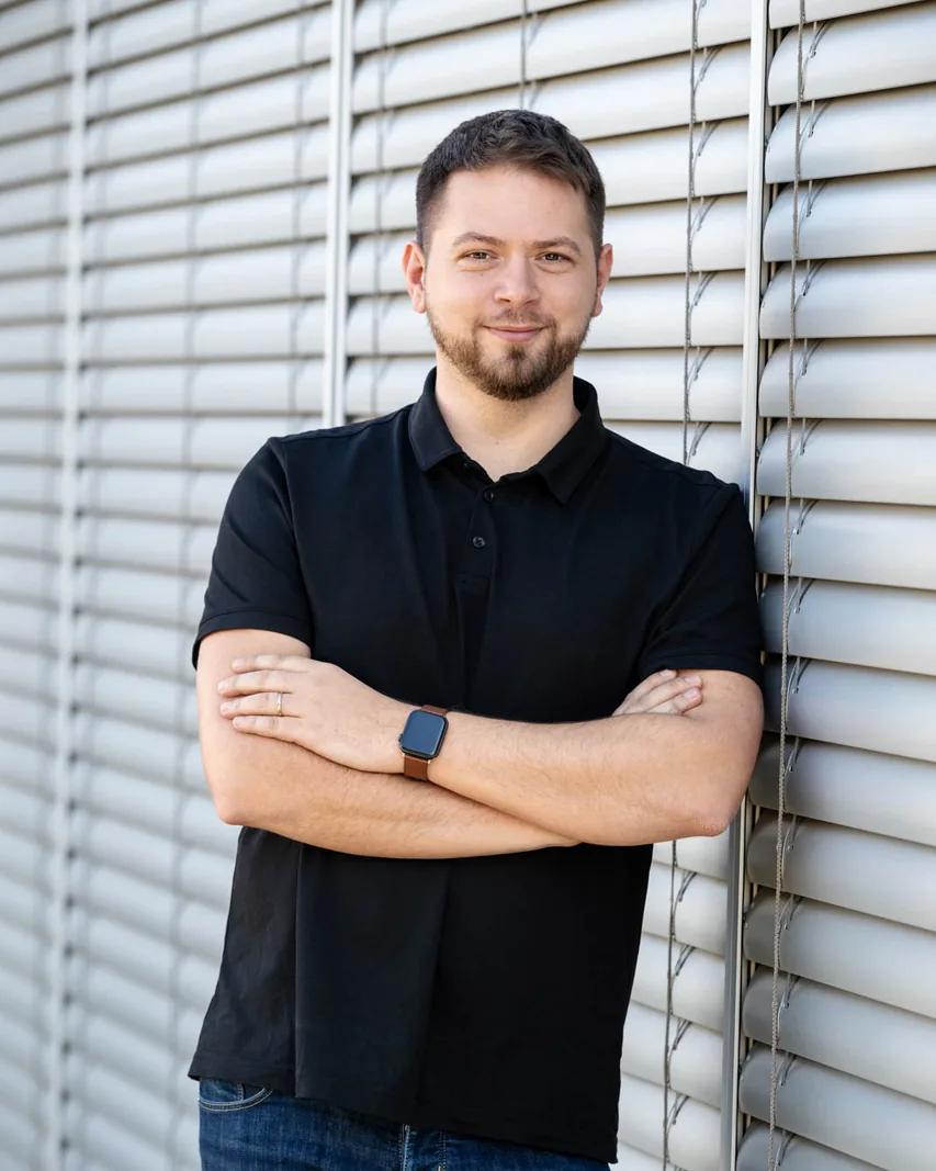 Martin Mařík, jednatel HOORAY s.r.o., se zkříženýma rukama před světlými žaluziemi